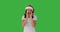 Cheerful woman in santa hat whispering secret over green screen