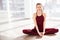 Cheerful woman smiling and doing yoga in studio