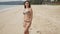 Cheerful woman standing on exotic beach during holiday