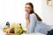 Cheerful woman standing in kitchen, ready to cook healthy salad