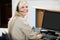 Cheerful Woman Using Computer At Reception Desk