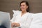 Cheerful woman using her laptop in the bedroom