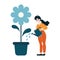 Cheerful woman watering a large blooming flower in a pot