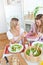 Cheerful women eating salad and bread during lunch