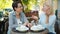 Cheerful women laughing talking having fun relaxing in street cafe on summer day