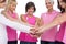 Cheerful women posing in circle holding hands wearing pink for b