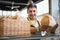 Cheerful worker standing and presenting a bread