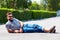 Cheerful young adult man lying on the road