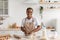 Cheerful young african american female chef blogger in apron making pie dough