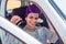 Cheerful young african american woman in a purple turban on head showing her new car key at summer beach.indian female