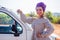 Cheerful young african american woman in a purple turban on head showing her new car key at summer beach.indian female