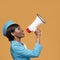 Cheerful young african stewardess shouts into the loudspeaker.