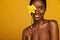 Cheerful young african woman with yellow makeup on her eyes. Female model laughing against yellow background with yellow