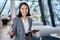 Cheerful young Asian saleswoman looking at camera welcoming client.