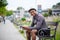 Cheerful young black man commuter sitting on bench outdoors in city.