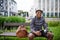 Cheerful young black man commuter sitting on bench outdoors in city.