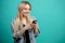 Cheerful young caucasian female using smartphone on blue