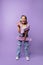 Cheerful young caucasian girl with skateboard, headphones wear casual clothes posing in studio.