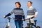 Cheerful young couple biking on beach outdoors