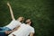 Cheerful young couple having rest on green grass