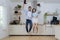 Cheerful young european lady and male washing dishes in modern kitchen interior. Hygiene, household chores in spare time. Young