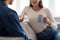 Cheerful young european wife with cup talking with husband in cozy living room interior