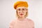 Cheerful young girl with an attractive appearance, a wide smile, dressed in yellow beret, warm pink knitted sweater