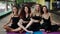 Cheerful young girls in sportwear sit in an embrace on the floor, after practicing yoga