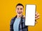 Cheerful Young Guy Demonstrating Smartphone With Big Blank White Screen, Mockup