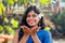 Cheerful young indian woman with white flover in hair relaxing sending kiss air on beach in Goa
