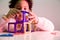 Cheerful young Latin child sitting at a table and playing with a vibrant building blocks