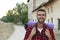 Cheerful young man with beard is walking through a small European town with backpack