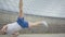 Cheerful young man dancing break dance in front of glass building outdoors. Portrait of confident strong Caucasian boy