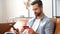 Cheerful young man holds credit card and a smartphone in hands, shopping online