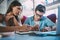 Cheerful young man and woman watching funny webinar on netbook in cafe