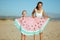Cheerful young mother and child holding funny watermelon towel