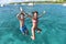 Cheerful young people jumping to the sea from the boat