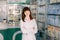 Cheerful young smiling Caucasian pharmacist chemist woman standing in pharmacy drugstore