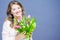 Cheerful young woman with bunny ears and Easter egg basket and tulips Flowers Looking at camera