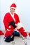 Cheerful young woman in christmas outfit accompanied by two sweet poodles.