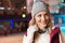 cheerful young woman in earphones looking away while ice skating