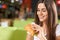 Cheerful young woman enjoying tasty snack in cafe