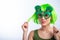 Cheerful young woman in green wig and funny glasses celebrating st patrick's day on a white background. Copy space