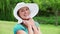 Cheerful young woman holding her hat brim