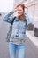 Cheerful young woman looking aroun on street in city