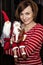 Cheerful young woman posing with two santas, Christmas scene