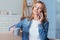 Cheerful young woman talking on the phone while drinking tea