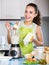 Cheerful young woman using kitchen blender