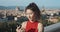 Cheerful young woman using smartphone or phone and typing message and smiling to camera. Vacation in Florence, Italy