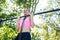 Cheerful young woman wearing pink sports bra while doing chin-up